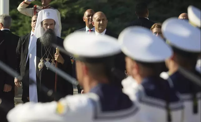 Bulgarian Patriarch Daniil looks at the Bulgarian honor guards marching to mark his enthronement ceremony in front of Alexander Nevsky Cathedral in Sofia, Bulgaria, Sunday, June 30, 2024. Bulgaria's Orthodox Church on Sunday elected Daniil, a 52-year-old metropolitan considered to be pro-Russian, as its new leader in a disputed vote that reflects the divisions in the church and in the society. (AP Photo/Valentina Petrova)