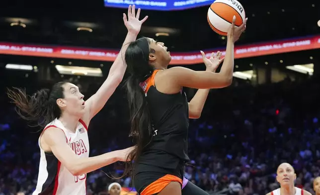 CORRECTS TO REESE NOT REECE - Angel Reese, front right, of Team WNBA, drives past Breanna Stewart, left, of Team USA, to score during the second half of a WNBA All-Star basketball game Saturday, July 20, 2024, in Phoenix. (AP Photo/Ross D. Franklin)