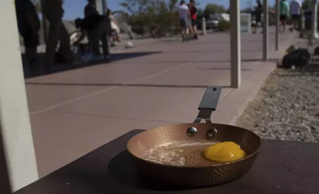 An egg lays in a small frying pan at the Furnace Creek Visitors Center in Death Valley National Park, Calif., Sunday, July 7, 2024. Forecasters say a heat wave could break previous records across the U.S., including in Death Valley. (AP Photo/Ty ONeil)