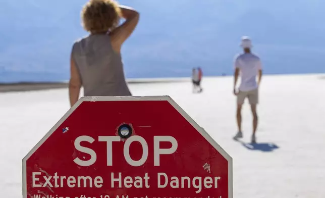 A person wipes sweat from their brow at Badwater Basin in Death Valley National Park, Calif., Sunday, July 7, 2024. Forecasters say a heat wave could break previous records across the U.S., including in Death Valley. (AP Photo/Ty ONeil)