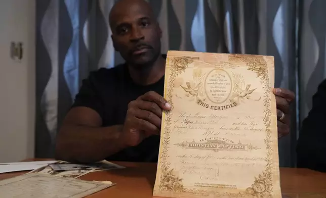 Matthew Burgess holds up the birth certificate for his grandfather, Rufus Morgan Burgess Jr., at his home Monday, Oct. 9, 2023, in Sacramento, Calif. (AP Photo/Godofredo A. Vásquez)