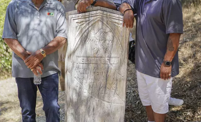 Descendants from Nelson Bell, relatives from left: brothers, Milford Fonza and Elmer Fonza, Trent Mure, and William Woolery pose for a picture at the tombstone of Nelson Bell (1790-1869) at the Pioneer Cemetery in Coloma, El Dorado County, Calif., on June 2023. (Elmer Fonza Family Photo via AP)