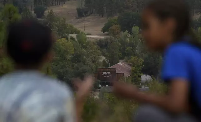 The present-day Grange Hall, center, is seen as school children, foreground, visit Marshall Gold Discovery State Historic Park, Tuesday, Oct. 10, 2023, in Coloma, Calif. (AP Photo/Godofredo A. Vásquez)