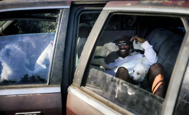 David Clarke who is suffering homelessness and living in his car with his 6 dogs, takes to the shade at the Sepulveda Basin dog park in Los Angeles on Tuesday, July 9, 2024. Dozens of locations in the West and Pacific Northwest tied or broke previous heat records over the weekend and are expected to keep doing so into the week. (AP Photo/Richard Vogel)