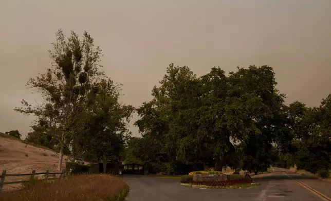 The gate to Sycamore Valley Ranch, formerly called Neverland Ranch when it was owned by Michael Jackson, stands as the Lake Fire advances in Los Olivos, Calif., Saturday, July 6, 2024. (AP Photo/Eric Thayer)