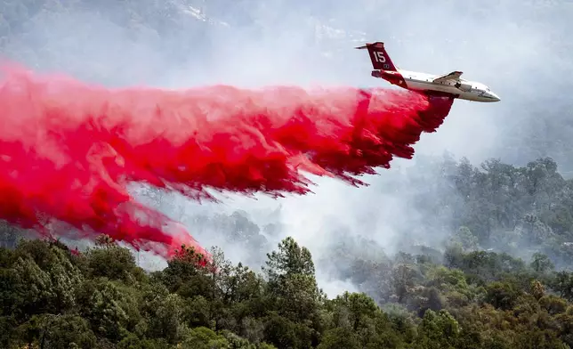 An air tanker drops retardant while trying to stop the Thompson Fire from spreading in Oroville, Calif., Wednesday, July 3, 2024. An extended heatwave blanketing Northern California has resulted in red flag fire warnings and power shutoffs. (AP Photo/Noah Berger)