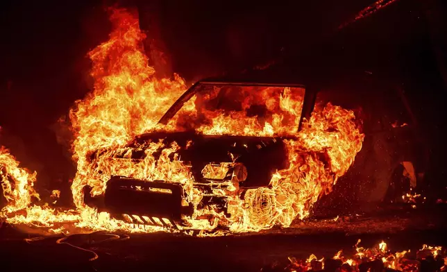 Flames consume a vehicle as the Park Fire jburns in Tehama County, Calif., on Friday, July 26, 2024. (AP Photo/Noah Berger)