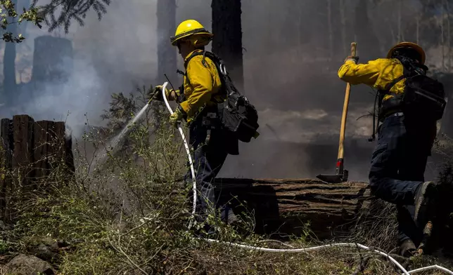 Firefighters put out hot spots from the Park Fire along Highway 32 near Forest Ranch, Calif., Tuesday, July 30, 2024. (AP Photo/Nic Coury)