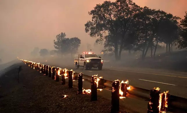 Rail posts burn along Highway 36 as the Park Fire spreads near Paynes Creek in Tehama County, Calif., on Friday, July 26, 2024. (AP Photo/Noah Berger)