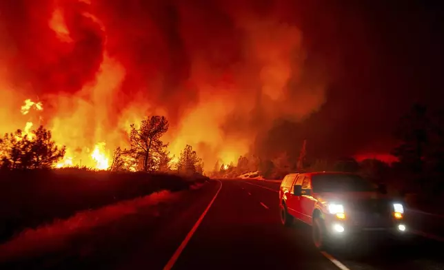 Smoke rises above the roadway as the Park Fire jumps Highway 36 near Paynes Creek in Tehama County, Calif., on Friday, July 26, 2024. (AP Photo/Noah Berger)