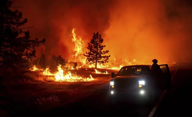 Flames burn as the Park Fire jumps Highway 36 near Paynes Creek in Tehama County, Calif., on Friday, July 26, 2024. (AP Photo/Noah Berger)