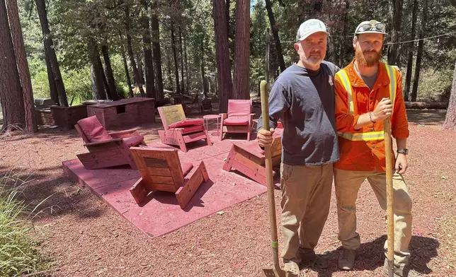 Ron Ward, 63, and son Ethan, 31, pose for a photo on their ranch in Cohasset Calif., Monday, July 29, 2024. They've been driving around in a off road cart vehicle putting out spot fires and informing their evacuated neighbors that their homes burned down. Firefighters made progress and were helped by improving weather over the weekend in the battle against wildfires covering massive areas in the western United States, but further evacuations have been necessary as thousands of personnel tackle the flames. (AP Photo/Eugene Garcia)