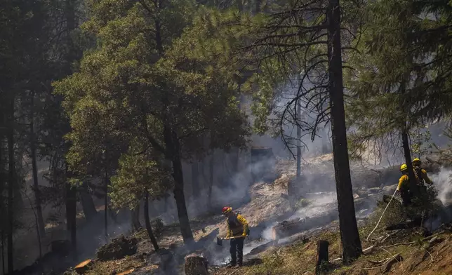 Firefighters put out hot spots from the Park Fire along Highway 32 near Forest Ranch, Calif., Tuesday, July 30, 2024. (AP Photo/Nic Coury)