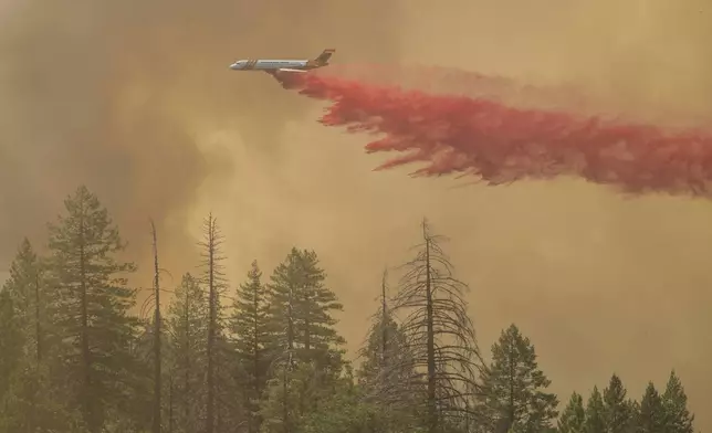 A plan drops fire retardant on the Park Fire near Forest Ranch, Calif., Sunday, July 28, 2024. (AP Photo/Nic Coury)