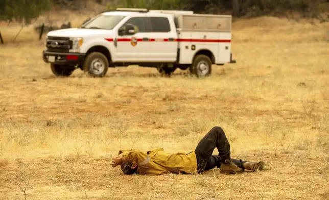 A firefighter rests during a break from battling the Park Fire in Tehama County, Calif., on Saturday, July 27, 2024. (AP Photo/Noah Berger)