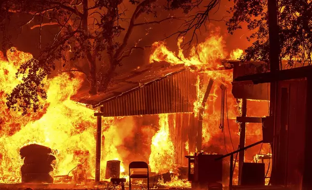 Flames consume structures as the Park Fire burns in Tehama County, Calif., on Friday, July 26, 2024. (AP Photo/Noah Berger)