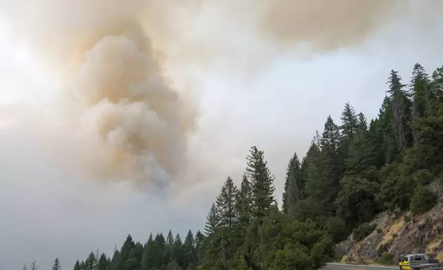 A column of smoke from the Park Fire rises over Highway 32 near Forest Ranch, Calif., Saturday, July 27, 2024. (AP Photo/Nic Coury)