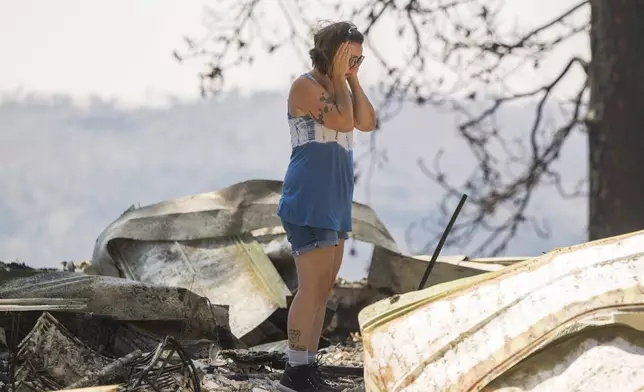 Andrea Blaylock becomes emotional as she sifts through the charred remains of her home that was destroyed in the Park Fire near Forest Ranch, Calif., Tuesday, July 30, 2024. (AP Photo/Nic Coury)