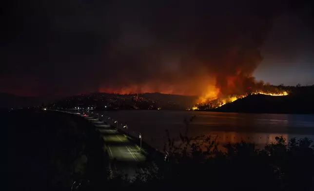 Flames are seen on a ridge at the Potters Ravine Recreation Area near Lake Oroville during the Thompson Fire in Oroville, Calif., Tuesday, July 2, 2024. (Stephen Lam/San Francisco Chronicle via AP)