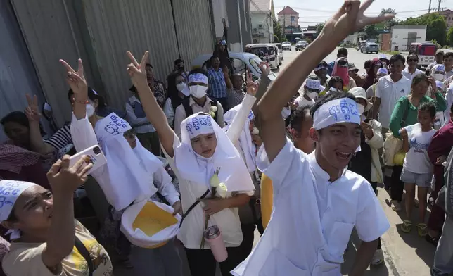 An environmental activist, front right, raises his V-sign together with supporters as he leads a protest near Phnom Penh Municipality Court, in Phnom Penh, Cambodia, Tuesday, July 2, 2024. Ten members of a nonviolent environmental activist group in Cambodia were convicted on Tuesday on charges of conspiracy to commit a crime, receiving prison sentences of six years each. (AP Photo/Heng Sinith)
