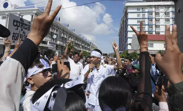 Environmental activists raise their V-sign during a protest near Phnom Penh Municipality Court, in Phnom Penh, Cambodia, Tuesday, July 2, 2024. Ten members of a nonviolent environmental activist group in Cambodia were convicted on Tuesday on charges of conspiracy to commit a crime, receiving prison sentences of six years each. (AP Photo/Heng Sinith)