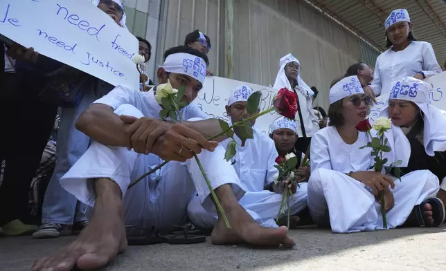 Environmental activists, front row, sit during a protest near Phnom Penh Municipality Court, in Phnom Penh, Cambodia, Tuesday, July 2, 2024. Ten members of a nonviolent environmental activist group in Cambodia were convicted on Tuesday on charges of conspiracy to commit a crime, receiving prison sentences of six years each. (AP Photo/Heng Sinith)