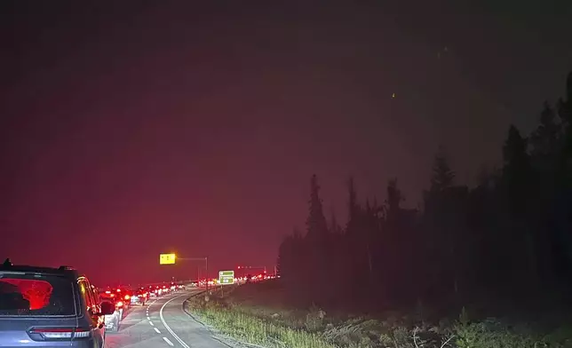 This photo provided by Carolyn Campbell shows cars clogging the highway as people evacuate because of wildfires early Tuesday, July 23, 2024, in Jasper, Alberta. Multiple wildfires in Canada’s Jasper National Park have flared up, forcing all park visitors along with the 4,700 residents of the Jasper townsite to flee. (Carolyn Campbell/The Canadian Press via AP)