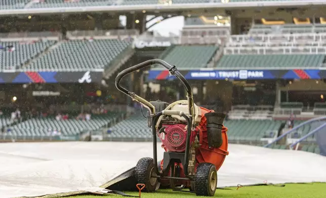 A blower is positioned in the infield to dry the field during the rain delay during a baseball game between the Atlanta Braves and the St. Louis Cardinals, Friday, July 19, 2024, in Atlanta. (AP Photo/Jason Allen)