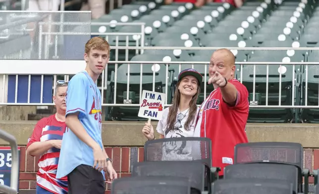 Atlanta Braves fans wait for the rain to pass before a baseball game against the St. Louis Cardinals, Friday, July 19, 2024, in Atlanta. (AP Photo/Jason Allen)