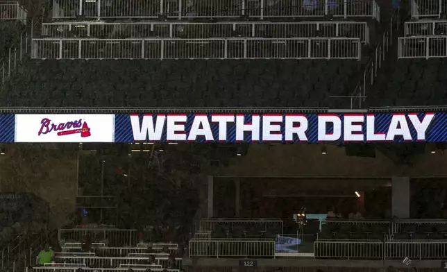 An infield scoreboard notifying the fans of a weather delay prior to a baseball game between the St. Louis Cardinals and Atlanta Braves, Friday, July 19, 2024, in Atlanta. (AP Photo/Jason Allen)