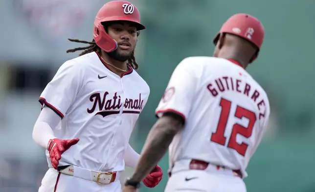 Washington Nationals' James Wood, left, is congratulated by third base coach Ricky Gutierrez after hitting a three-run home run during the second inning of a baseball game against the St. Louis Cardinals at Nationals Park, Saturday, July 6, 2024, in Washington. (AP Photo/Mark Schiefelbein)