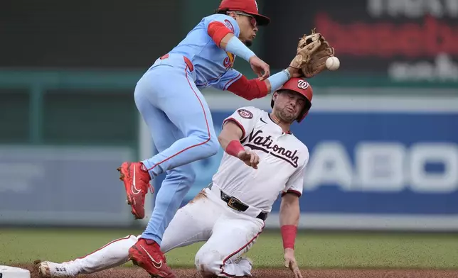 Washington Nationals' Lane Thomas, right, collides with St. Louis Cardinals shortstop Masyn Winn, left, while stealing second base during the first inning of a baseball game at Nationals Park, Saturday, July 6, 2024, in Washington. (AP Photo/Mark Schiefelbein)