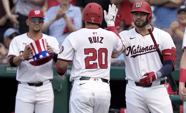 Washington Nationals' Keibert Ruiz (20) high-fives with Washington Nationals first baseman Juan Yepez, right, after hitting a three-run home run during the first inning of a baseball game against the St. Louis Cardinals at Nationals Park, Saturday, July 6, 2024, in Washington. (AP Photo/Mark Schiefelbein)