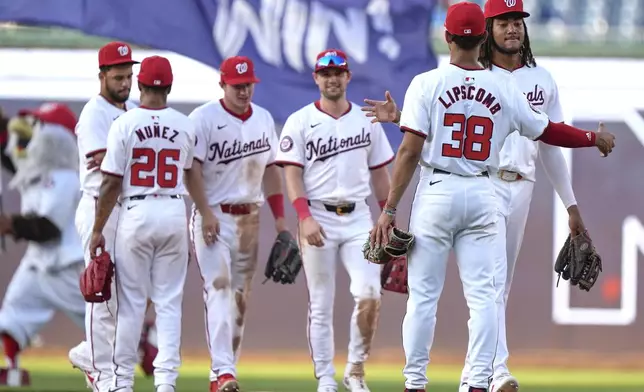 Washington Nationals left fielder James Wood, right, is congratulated by third baseman Trey Lipscomb (38) after a baseball game against the St. Louis Cardinals at Nationals Park, Saturday, July 6, 2024, in Washington. The Nationals beat the Cardinals, 14-6. (AP Photo/Mark Schiefelbein)