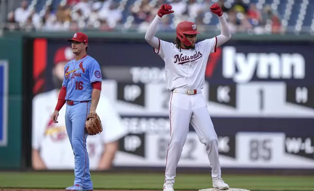 Washington Nationals' James Wood, right, reacts after hitting a two-RBI double during the third inning of a baseball game against the St. Louis Cardinals at Nationals Park, Saturday, July 6, 2024, in Washington. At left is St. Louis Cardinals second baseman Nolan Gorman (16). (AP Photo/Mark Schiefelbein)