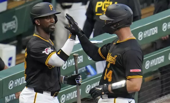 Pittsburgh Pirates' Joey Bart, right, is greeted by Andrew McCutchen as he returns to the dugout after driving in a run with a sacrifice fly off St. Louis Cardinals starting pitcher Miles Mikolas during the fifth inning of a baseball game in Pittsburgh, Wednesday, July 3, 2024. (AP Photo/Gene J. Puskar)