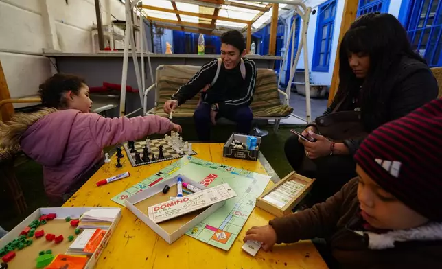 Venezuelan migrant couple Karen Salazar, second from right, and Luis Henrique, center, play with their children Malin and Sebastian at the shelter "Nuestra Casa" our Our Home in the Yungay neighborhood of Santiago, Chile, Thursday, May 30, 2024. After fleeing Venezuela and finding life as a migrant intolerable in Colombia and then Ecuador, the family migrated to Chile. (AP Photo/Esteban Felix)