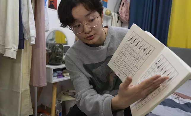 Lu Sirui, a 24-year-old working as a marketer, talks about nüshu, a centuries-old secret script, that she has learned from online feminist groups, in Beijing, March 18, 2024. (AP Photo/Olivia Zhang)