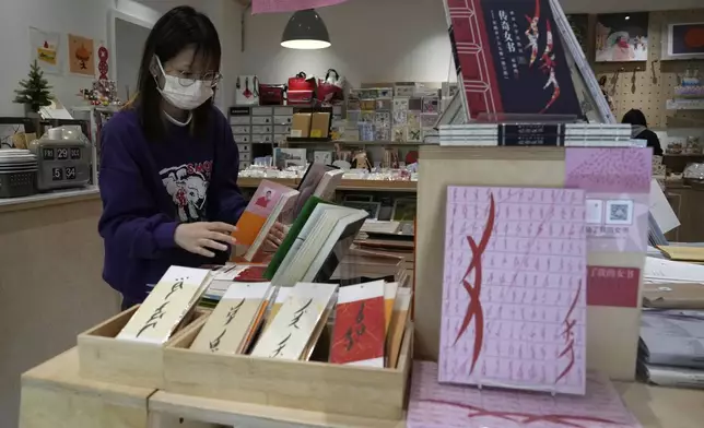 A worker arranges books at a bookstore specializing in nüshu, a centuries-old secret script, in Chengdu in southwestern China's Sichuan province, March 17, 2024. (AP Photo/Ng Han Guan)