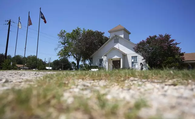 A woman visits the First Baptist Church in Sutherland Springs, Texas, Tuesday, July 2, 2024, which is now a memorial to the 26 people who were killed by a gunman in 2017. The 100-year-old building has served as a memorial since the shooting, but now some want to raze the building. (AP Photo/Eric Gay)