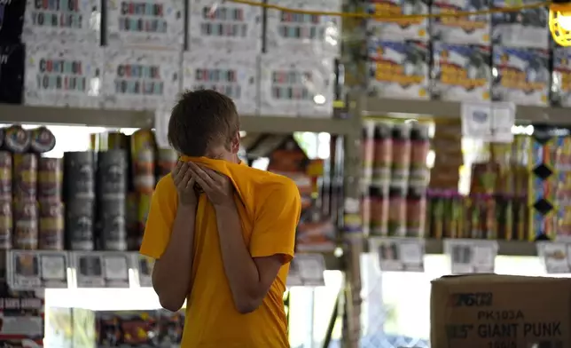 FILE - Hunter Van Dyne pauses to wipe sweat from his forehead inside a hot fireworks tent as he works to set up for the opening of Powder Monkey Fireworks, in Weldon Spring, Mo., Monday, June 17, 2024. June 2024 was the hottest June on record, according to Europe's Copernicus climate service on Monday, July 8. (AP Photo/Jeff Roberson, File)