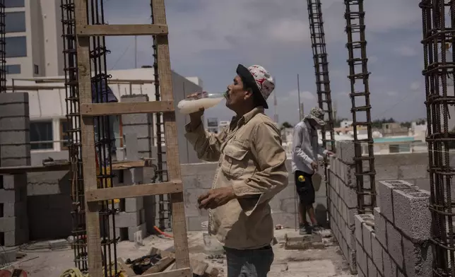 FILE - Jorge Moreno, a worker, drinks flavored water to cope with the heat wave during his workday at a construction site in Veracruz, Mexico on June 17, 2024. June 2024 was the hottest June on record, according to Europe's Copernicus climate service on Monday, July 8. (AP Photo/Felix Marquez, File)