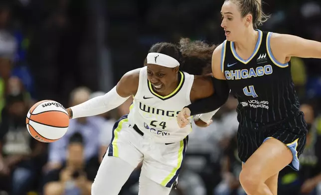 FILE - Dallas Wings guard Arike Ogunbowale, left, drives against Chicago Sky guard Marina Mabrey (4) during the first half of a WNBA basketball game May 15, 2024, in Arlington, Texas. The Wings were coming off their most successful season in Texas, with All-Star starters Satou Sabally and Ogunbowale among the core back from a team that made the WNBA semifinals. Sabally got hurt even before the season, the first of numerous injuries that have clipped the Wings, who are now just trying to hold on until the Olympic break. (AP Photo/Brandon Wade, File)