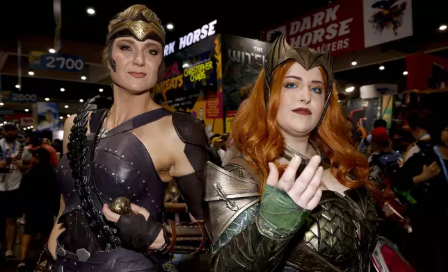 FILE - Susie Cramer of Oklahoma City, Okla., dressed as Antiope from "Wonder Woman," left, and Morgan Duhon of New Orleans, dressed as Mera from "Aquaman," attend Comic-Con International in San Diego on July 20, 2023. The comic book and pop culture extravaganza, which draws over 130,000 fans annually, opens for a preview night Wednesday and runs from Thursday through Sunday. (Photo by Christy Radecic/Invision/AP, File)