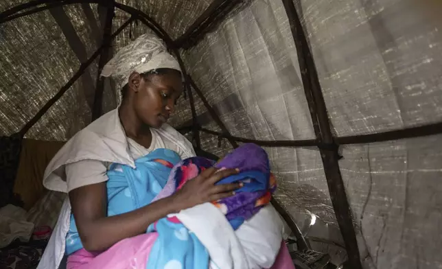 A young mother Alphonsinne Tchimbaye holds her month-old twins inside her tent at a refugee camp on the outskirts of Goma, Democratic Republic of the Congo, Thursday, July 11, 2024. The top U.N. official in Congo on Monday welcomed a two-week humanitarian cease-fire in its mineral-rich east, where she said violence has reached "alarming levels" and risked provoking a wider regional conflict. (AP Photo/Moses Sawasawa)
