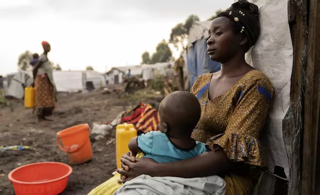 A mother Mapendo with her child sits outside her tent at a refugee camp on the outskirts of Goma, Democratic Republic of the Congo, Thursday, July 11, 2024. The top U.N. official in Congo on Monday, July 8, welcomed a two-week humanitarian cease-fire in its mineral-rich east, where she said violence has reached "alarming levels" and risked provoking a wider regional conflict. (AP Photo/Moses Sawasawa)