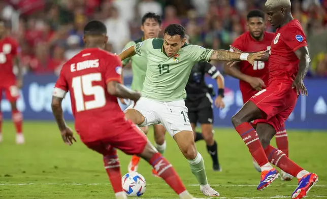 Bolivia's Bruno Miranda, center, dribbles the ball to score his side's first goal against Panama during a Copa America Group C soccer match in Orlando, Fla., Monday, July 1, 2024. (AP Photo/John Raoux)