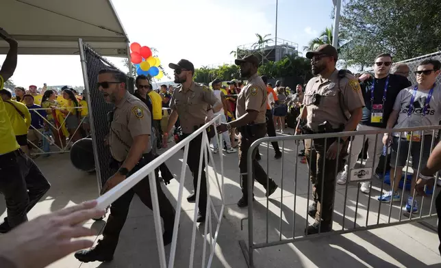 Police patrol the area as fans wait to enter at stadium prior to the Copa America final soccer match between Argentina and Colombia Sunday, July 14, 2024, in Miami Gardens, Fla. (AP Photo/Lynne Sladky)