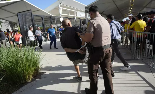 A man is detained by police outside the stadium prior to the Copa America final soccer match between Argentina and Colombia Sunday, July 14, 2024, in Miami Gardens, Fla. (AP Photo/Lynne Sladky)