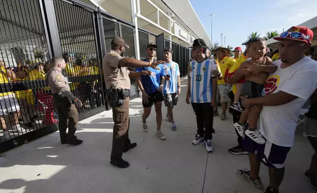 Police give instructions to fans outside the stadium prior to the Copa America final soccer match between Argentina and Colombia Sunday, July 14, 2024, in Miami Gardens, Fla. (AP Photo/Lynne Sladky)